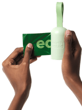 a hand holding a an earth rated dispenser with a refill bag coming out of it